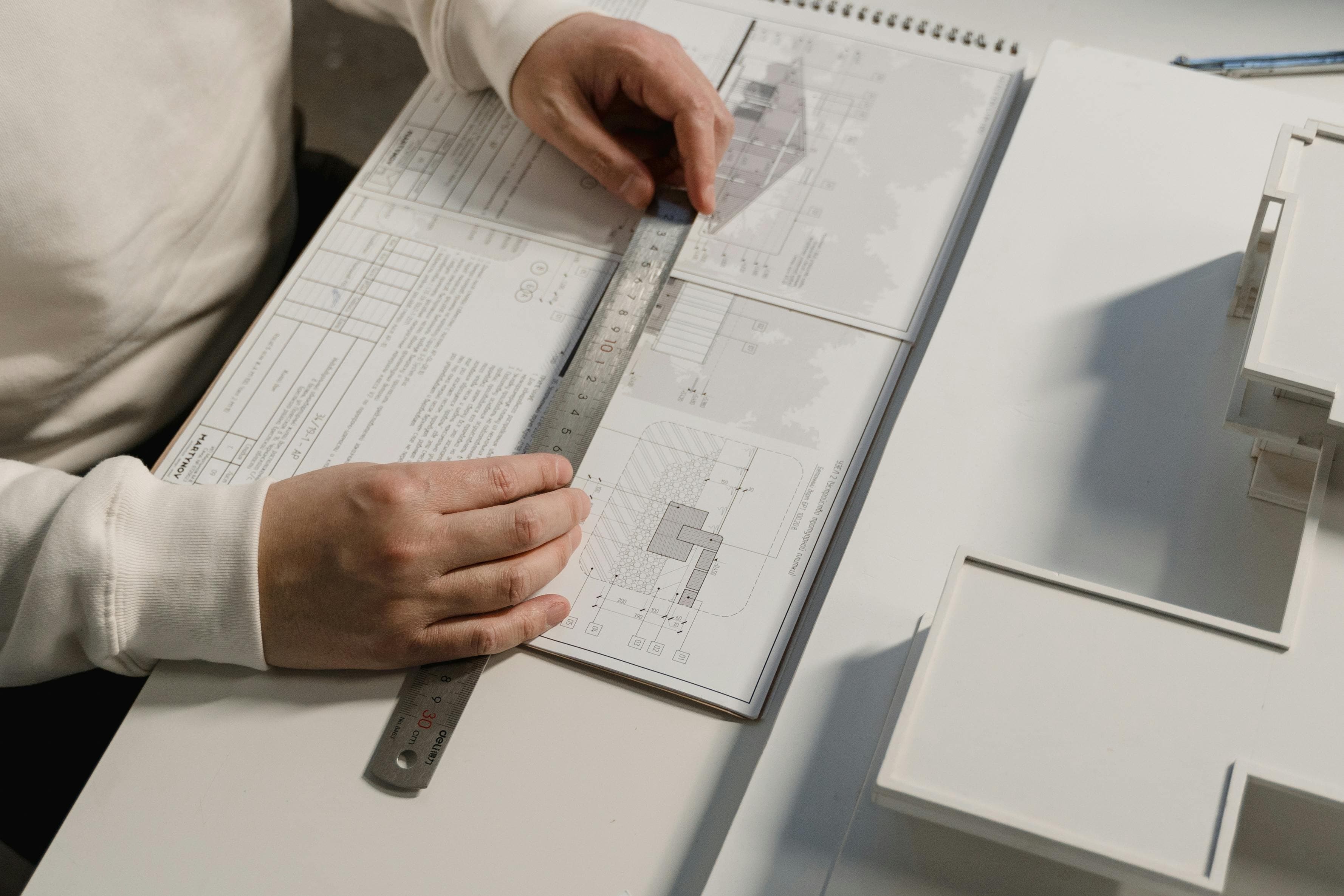 Professional reviewing architectural plans with a scale ruler